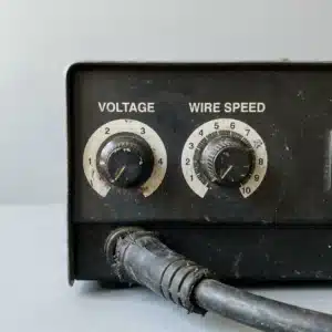MIG welder front panel with voltage and wire speed knobs