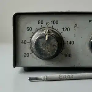 Stick welder amperage knob set near 90 amps, with a 7018 rod